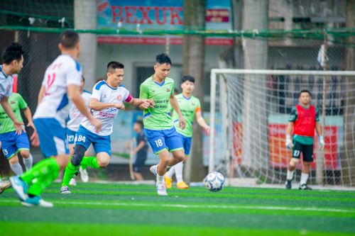 Free Dynamic action shot of an amateur soccer match in Hanoi, showcasing teamwork and athleticism. Stock Photo