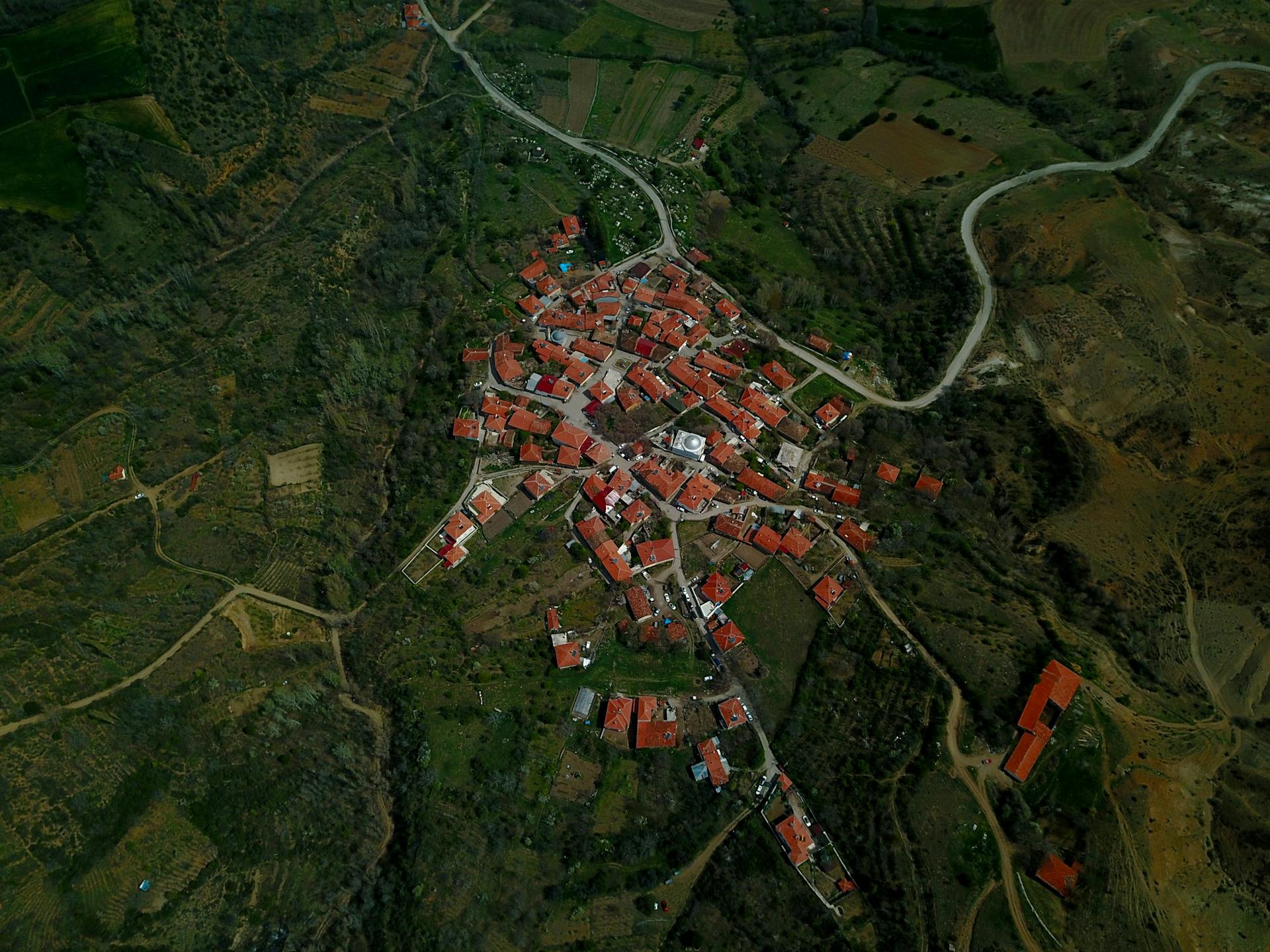 A stunning aerial view of a rural village with red-roofed houses at sunset.