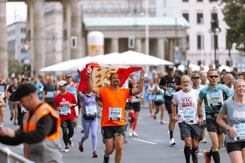 Vibrant marathon scene with runners near Berlin's iconic Brandenburg Gate, fostering athleticism and unity.