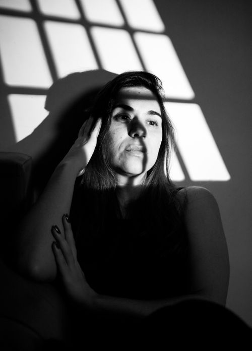 Free Artistic black and white portrait of a woman with dramatic lighting and shadows. Stock Photo