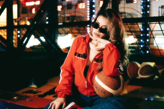 Fashion-forward woman in an arcade scene, holding a basketball.