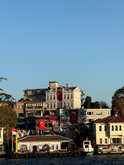 Free Historic waterfront buildings in Istanbul adorned with Turkish flags under a clear sky. Stock Photo