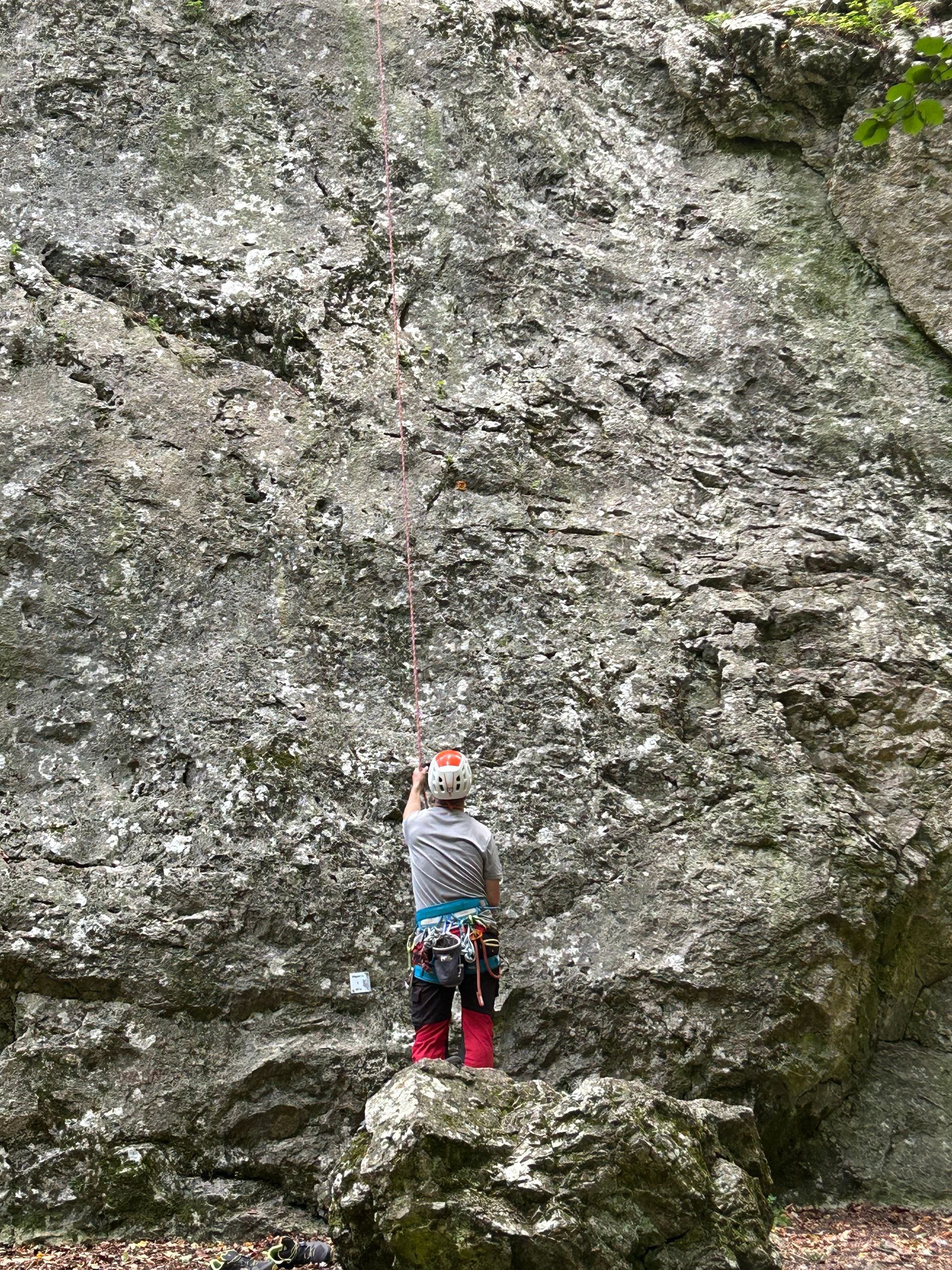 A climber on a rock face at Coll's Cove