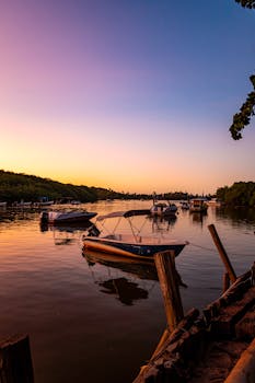 Tranquil sunset view of boats on a river in Bahia, Brazil, reflecting vivid skies.