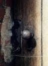 木质纹理门上，一个生锈的旧门把手的特写，展现了古色古香的魅力