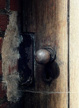 木质纹理门上，一个生锈的旧门把手的特写，展现了古色古香的魅力