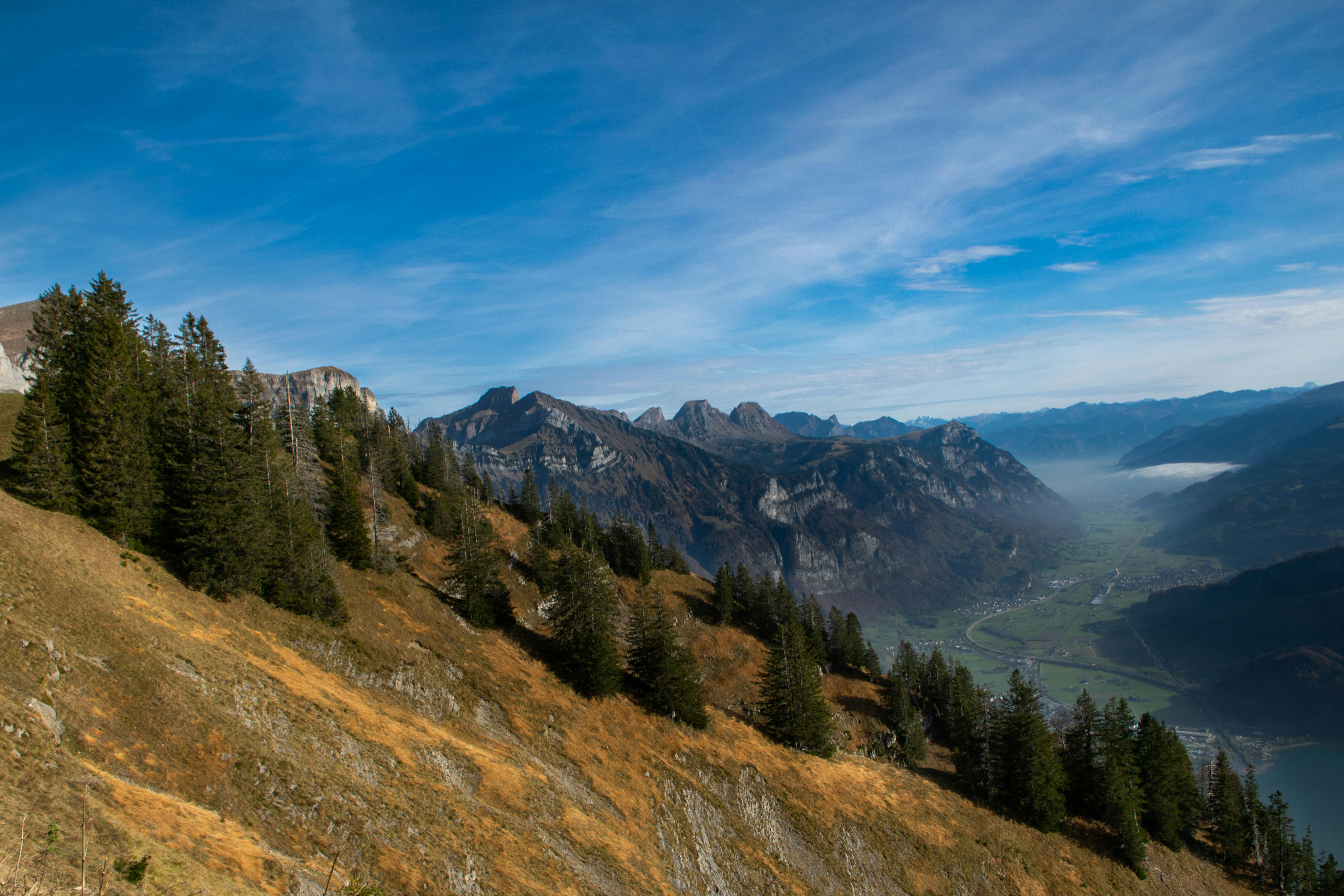 Scenic Mountain View with People Relaxing on Bench · Free Stock Photo