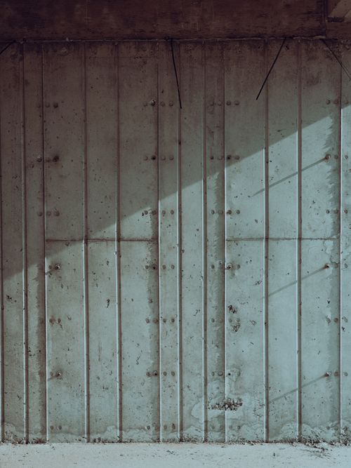 Free A textured concrete wall with diagonal shadows creating a minimalist abstract pattern. Stock Photo