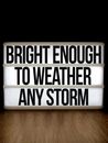 Motivational message on a lightbox with a wooden background promoting resilience and positivity.