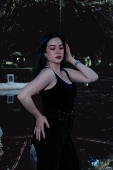 Stylish portrait of a young woman posing confidently in an outdoor setting during day.