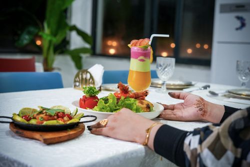Free Elegant dinner table with a vibrant fruit mocktail and delicious meal, perfect for a festive gathering. Stock Photo