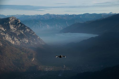 Free A drone flies over the scenic Walenstadt Valley in the Swiss Alps at sunrise, capturing stunning mountain views. Stock Photo