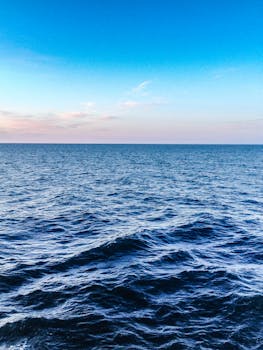 宁静的海景中，地平线、蔚蓝的海水与黄昏时分的晴朗天空相映成趣