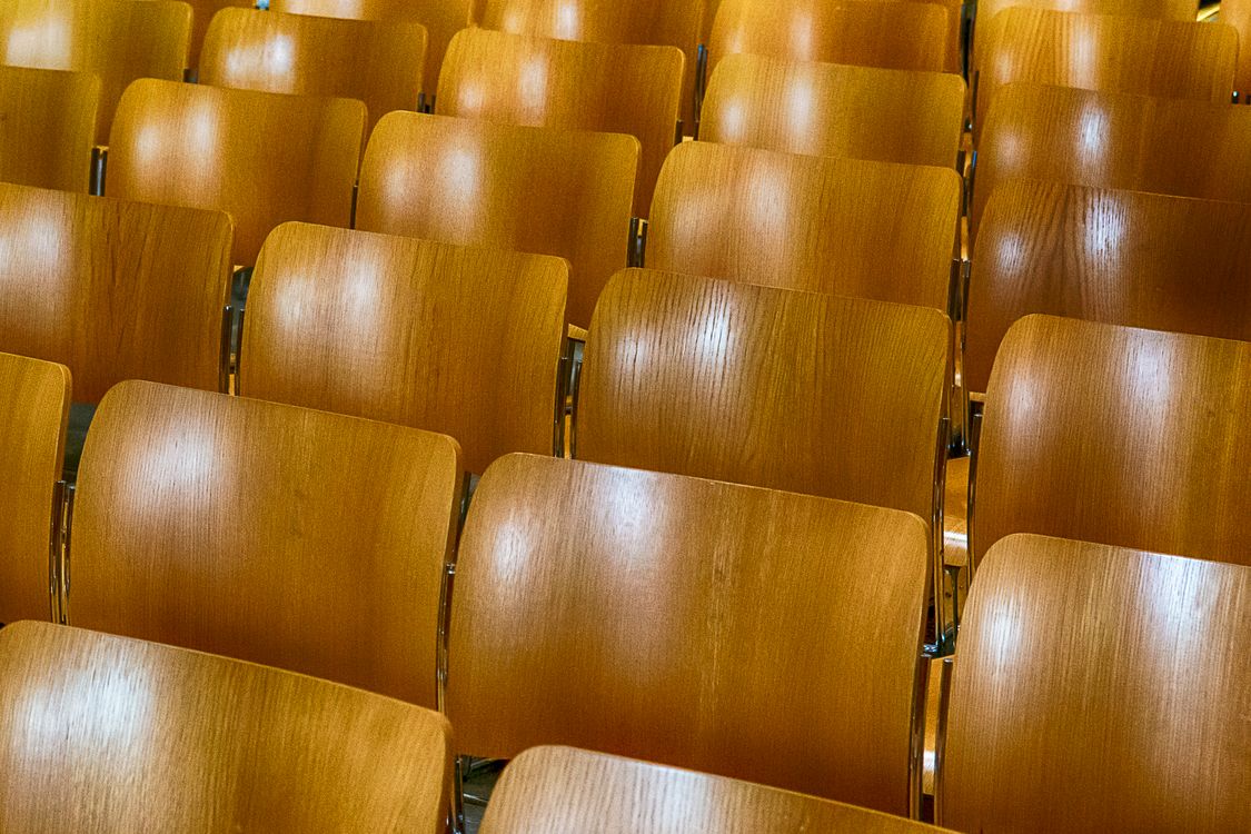 Empty Wooden Auditorium Seating Rows · Free Stock Photo