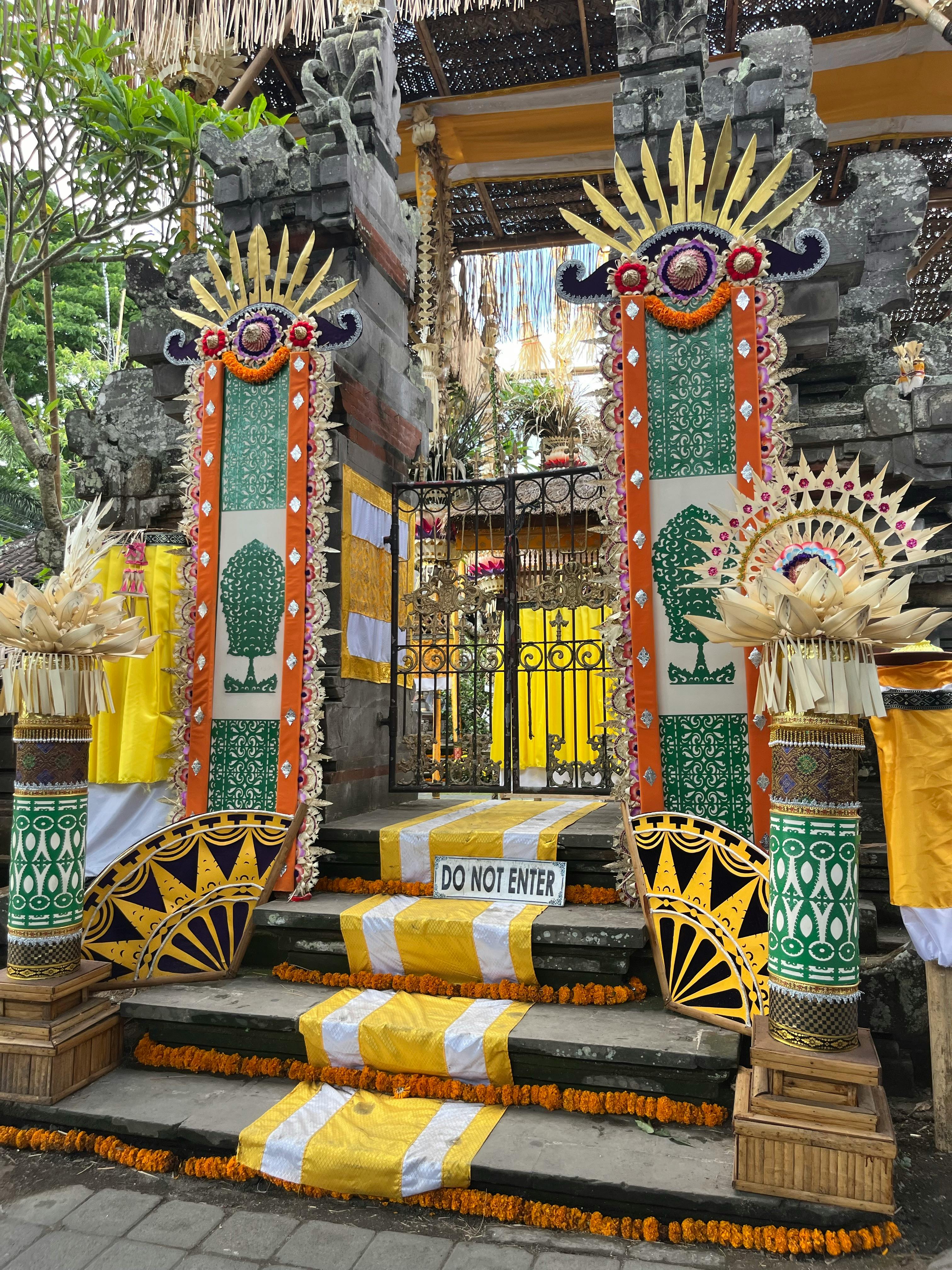 Traditional Balinese split gate with stone carvings and ceremonial offerings at a Hindu temple in Bali