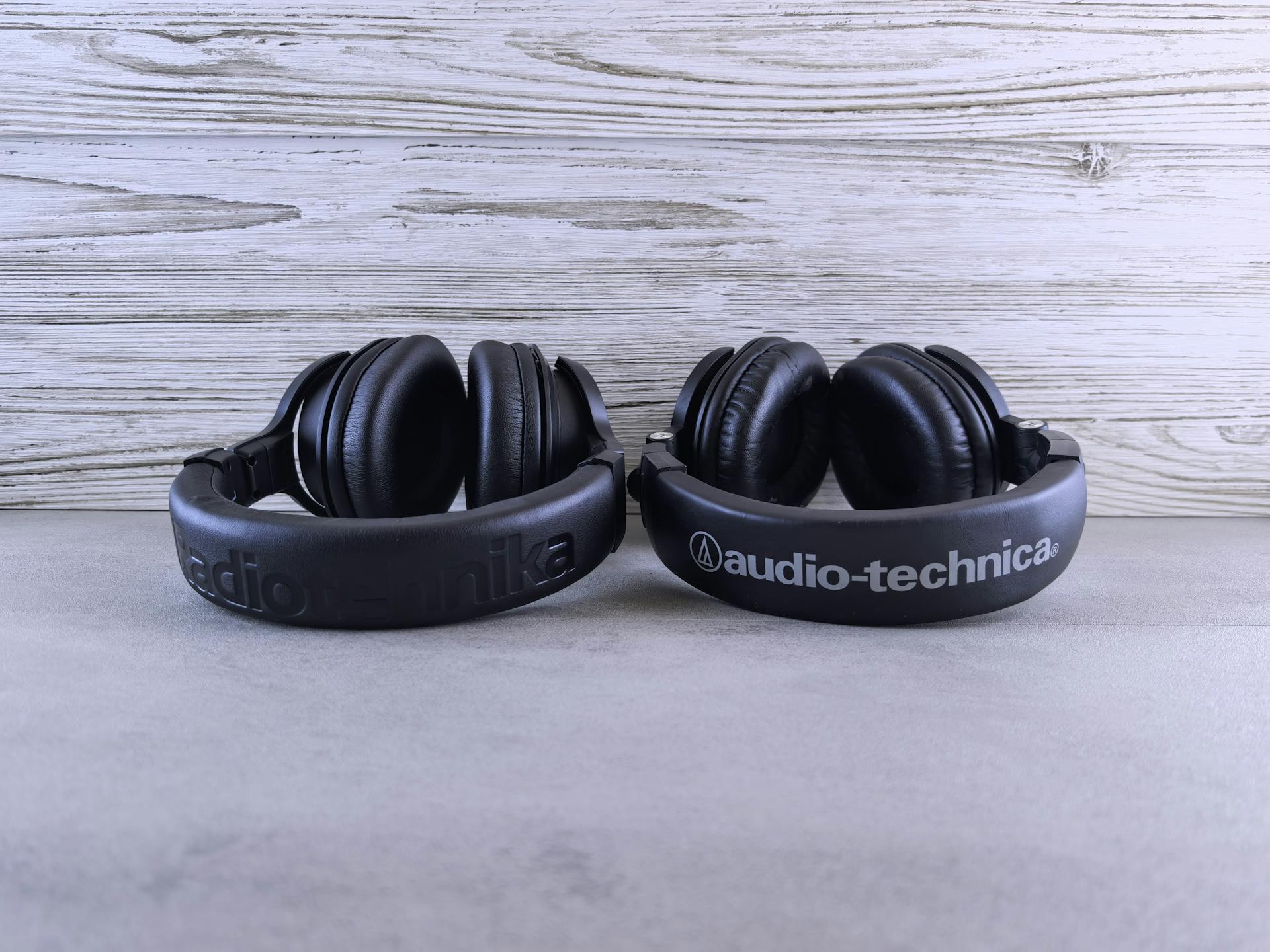 Pair of Audio-Technica headphones displayed on a textured wooden background.