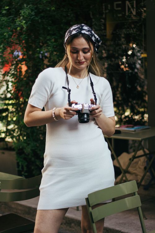 Free A young woman reviews her camera in an Istanbul cafe, capturing moments with a vintage vibe. Stock Photo