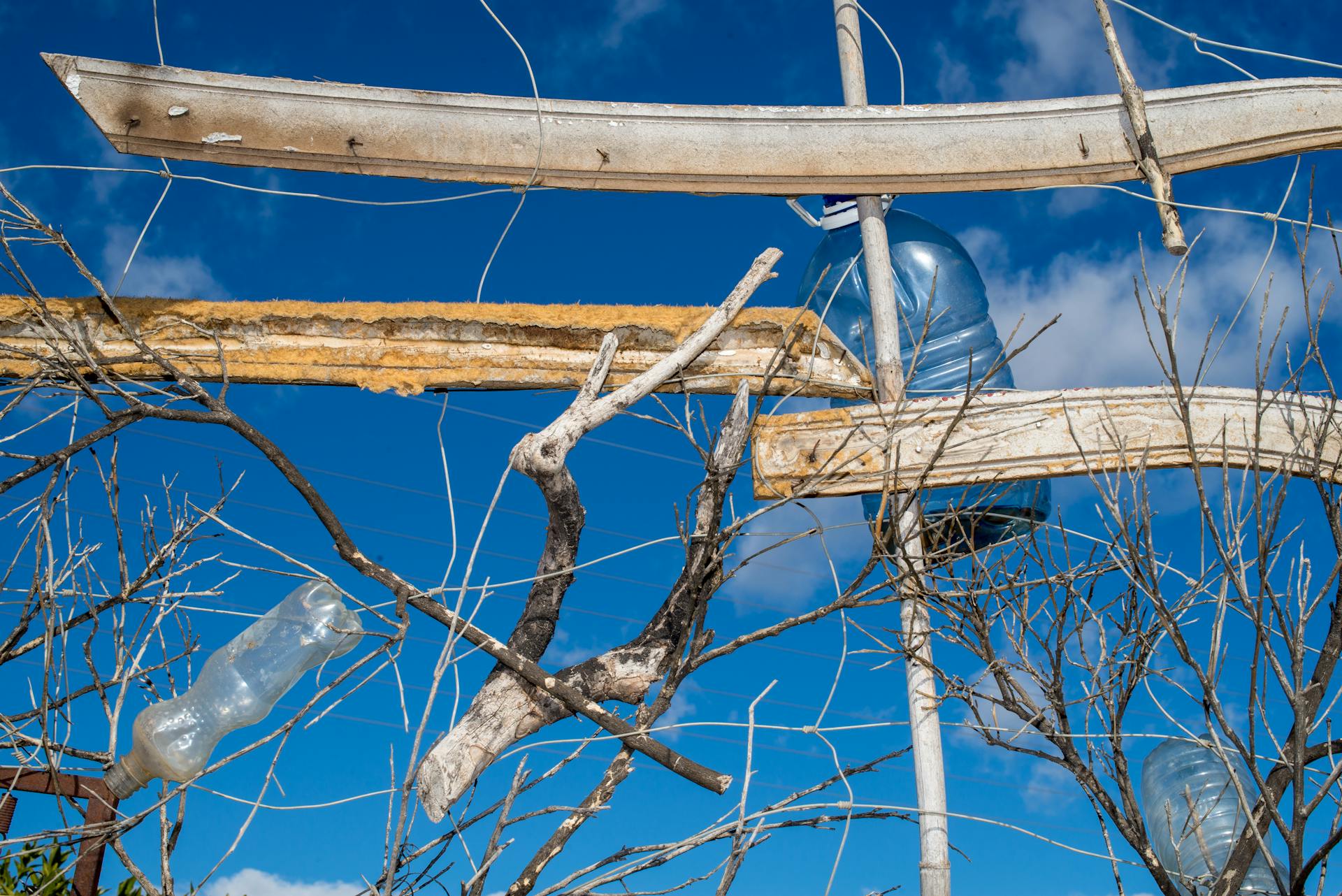 Abstract arrangement of wood and plastic against a clear blue sky.