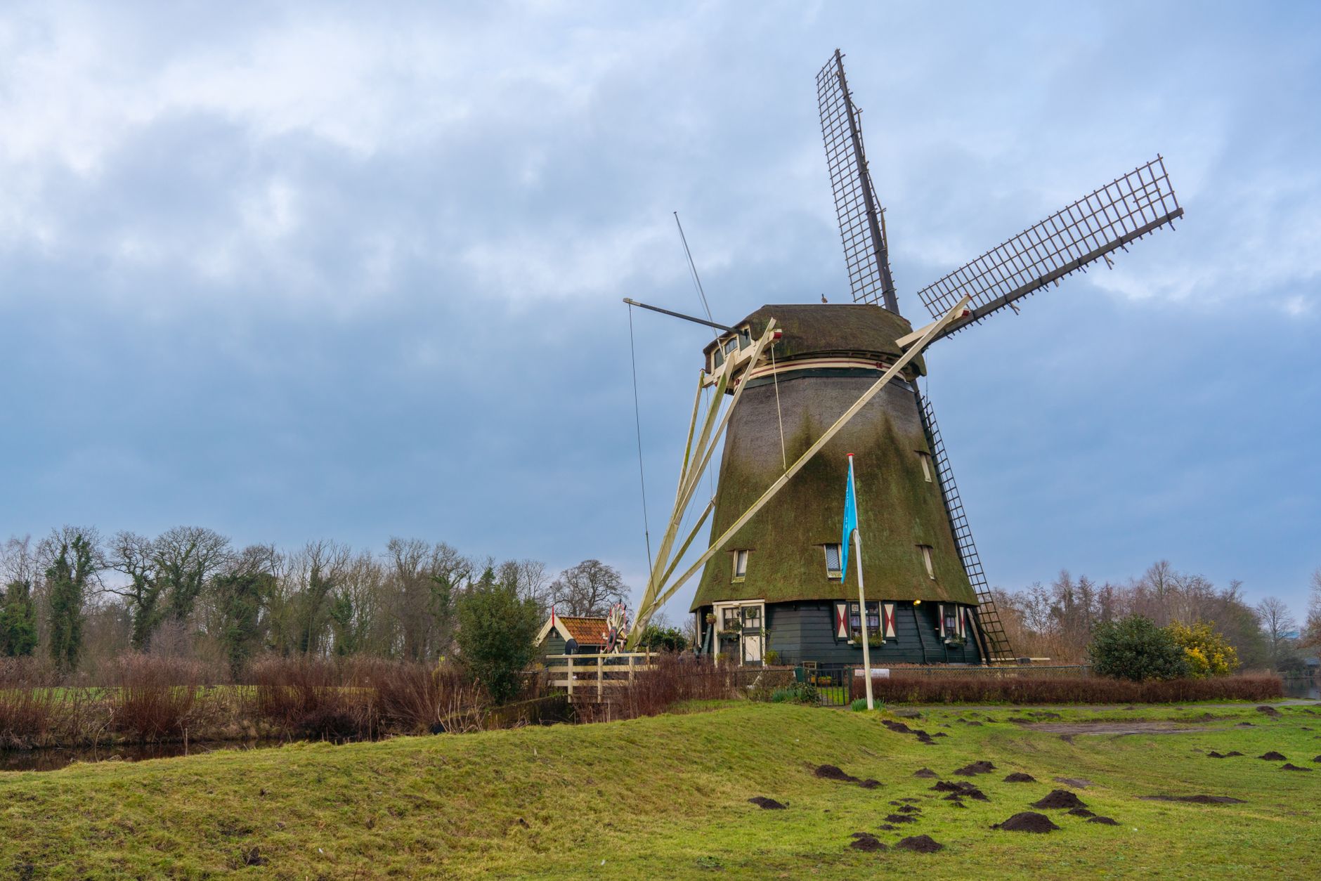 Classic Dutch windmill set against a scenic Amsterdam countryside view.