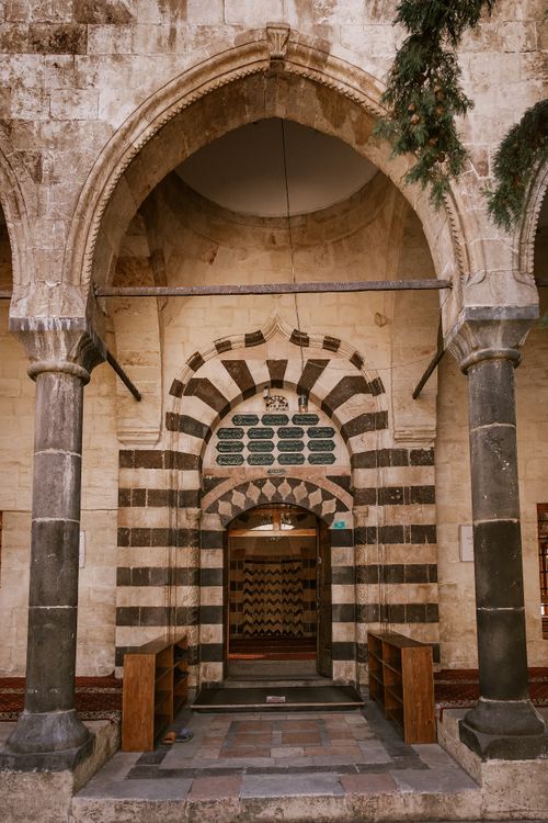 Free Intricate stone archway leading into a historic mosque, showcasing classic Islamic architecture. Stock Photo