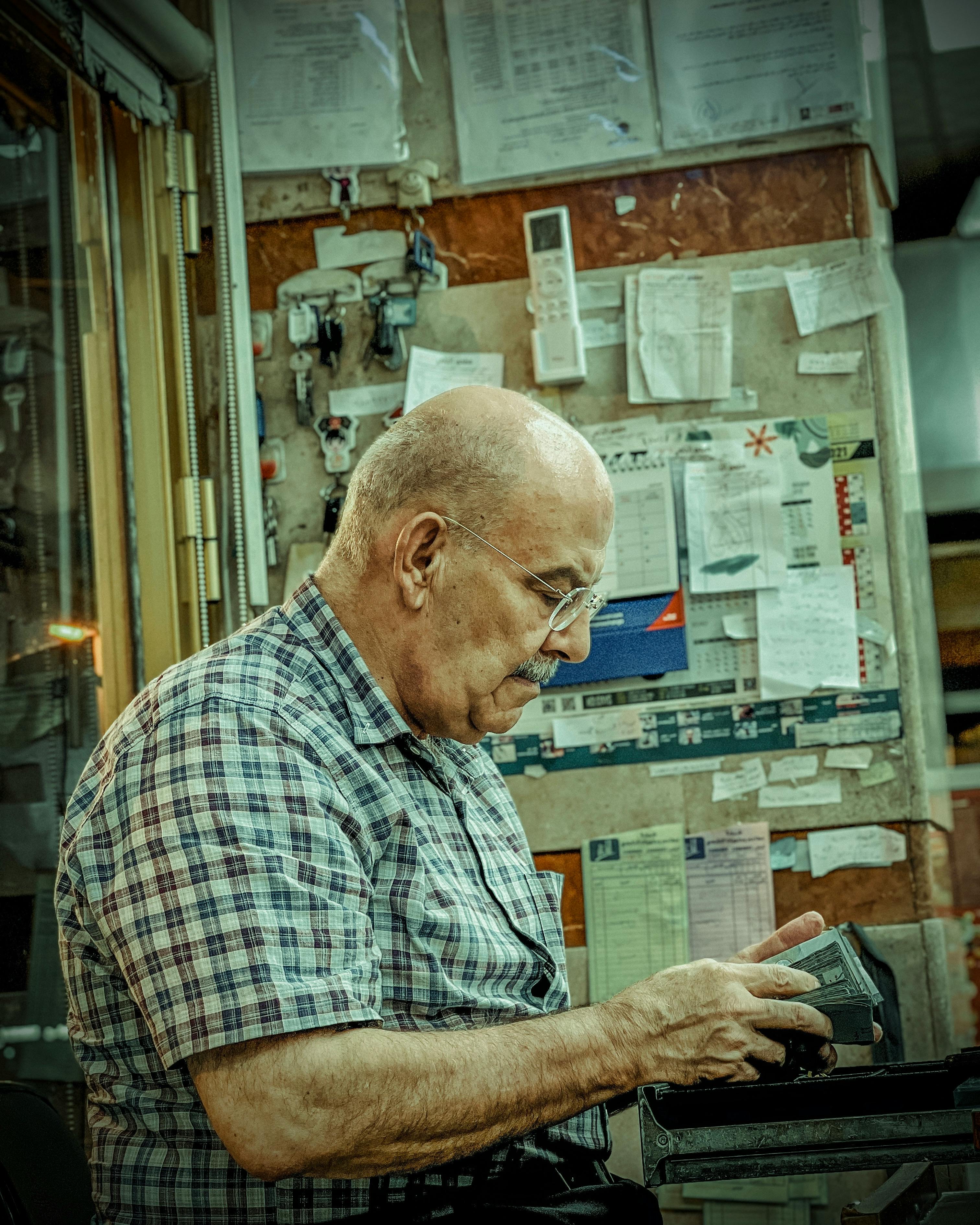 senior man counting money indoors