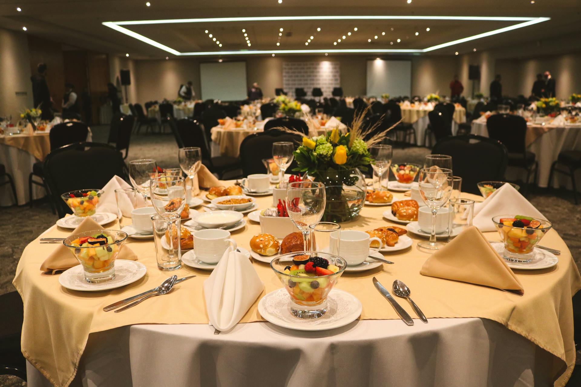 Luxurious banquet table with arranged dishes and floral centerpiece at a formal event setting.