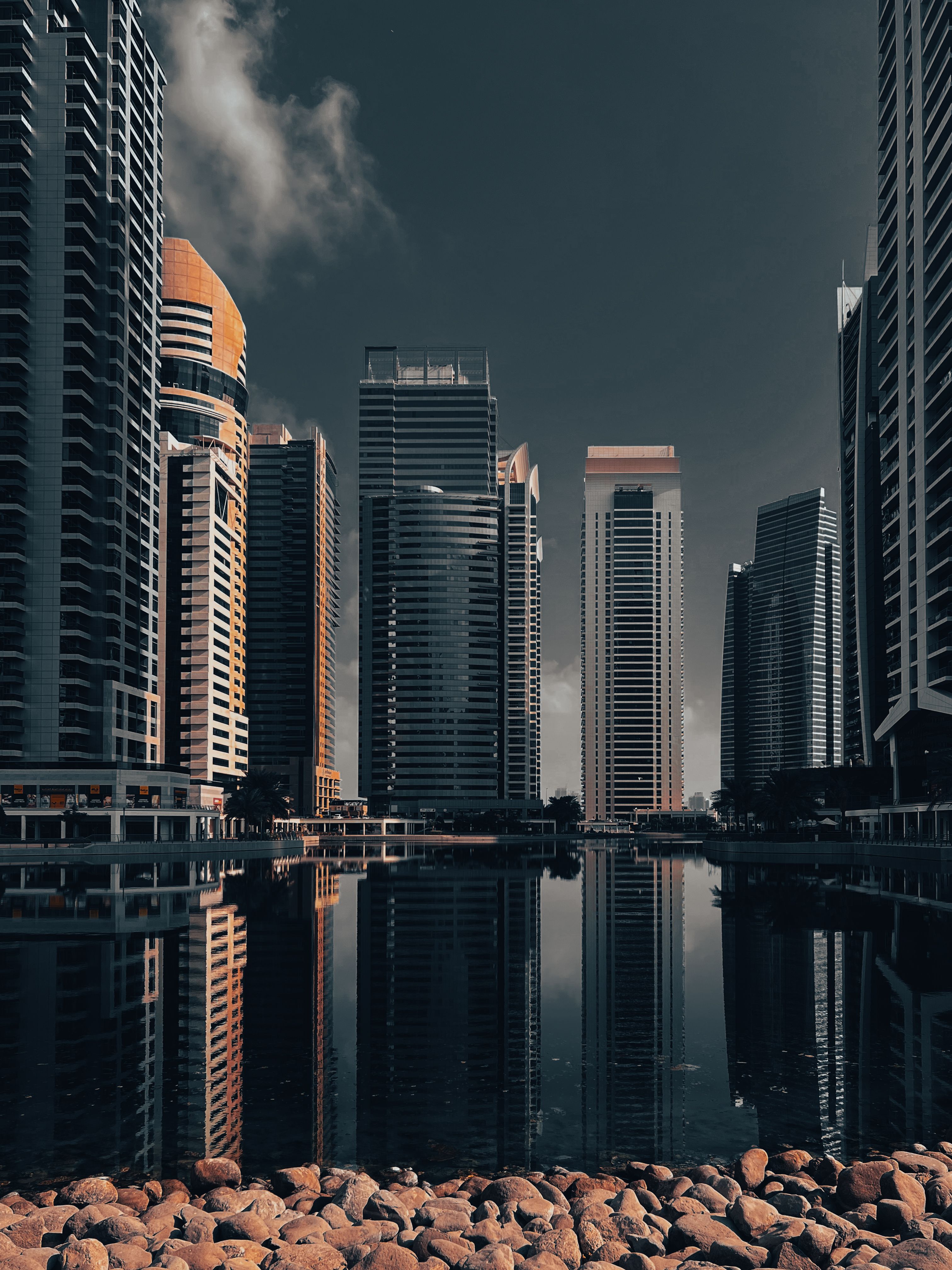 Majestic skyscrapers reflecting on a calm water surface in Dubai, creating a stunning skyline view.