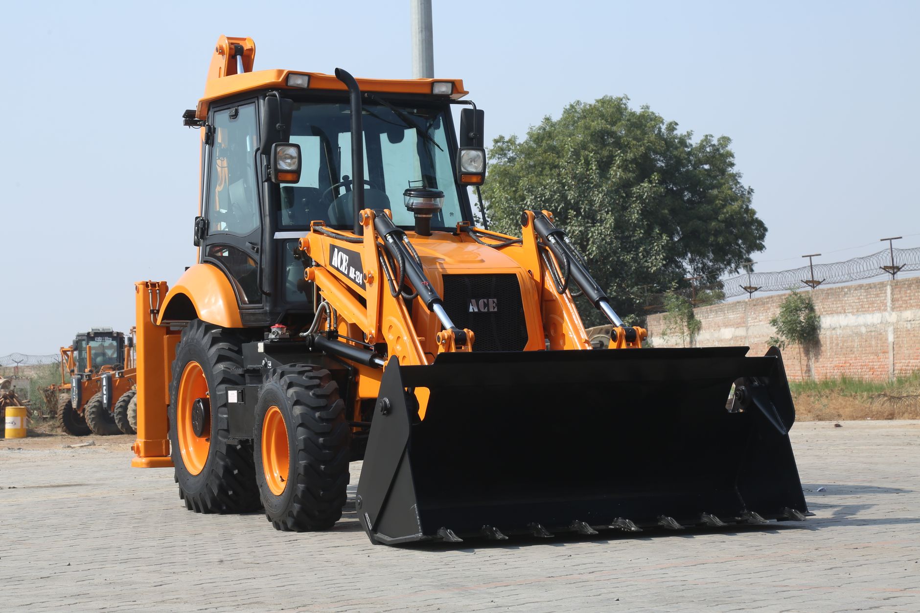 ACE AX 124 backhoe loader machine at a construction site in India.