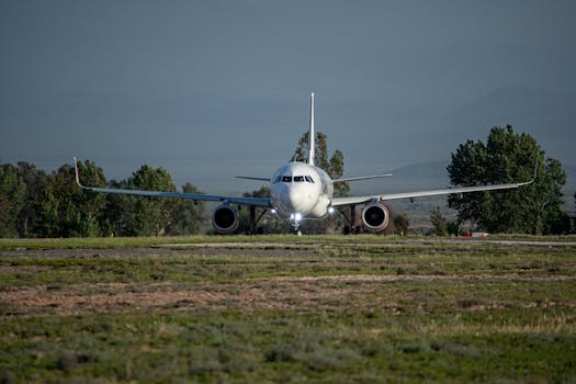 Front view of a commercial airplane preparing for takeoff on a runway with clear skies.