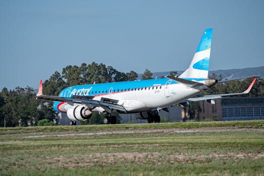 A commercial airplane preparing for takeoff on a sunny day with blue sky backdrop.