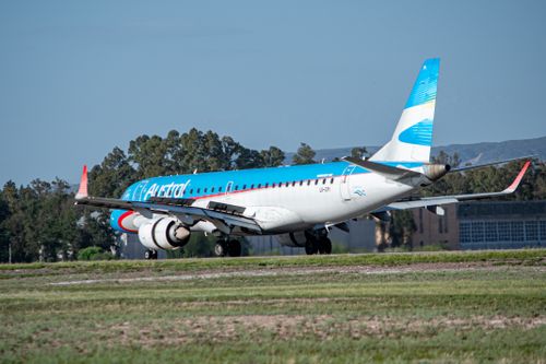 Free A commercial airplane preparing for takeoff on a sunny day with blue sky backdrop. Stock Photo
