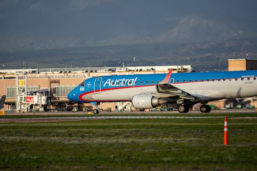 Austral Airlines Embraer aircraft on runway at Mendoza Airport with Andes backdrop.