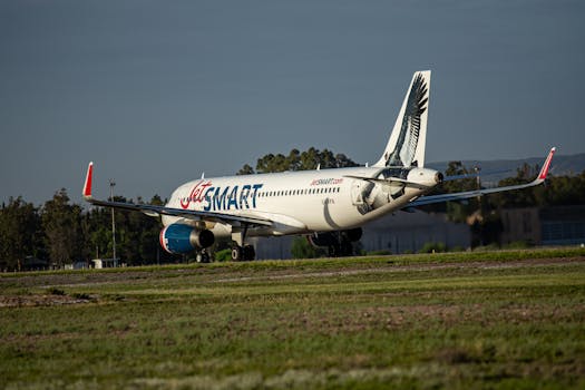 JetSMART aircraft taxiing on runway with distinctive tail design. Clear sky and day setting.