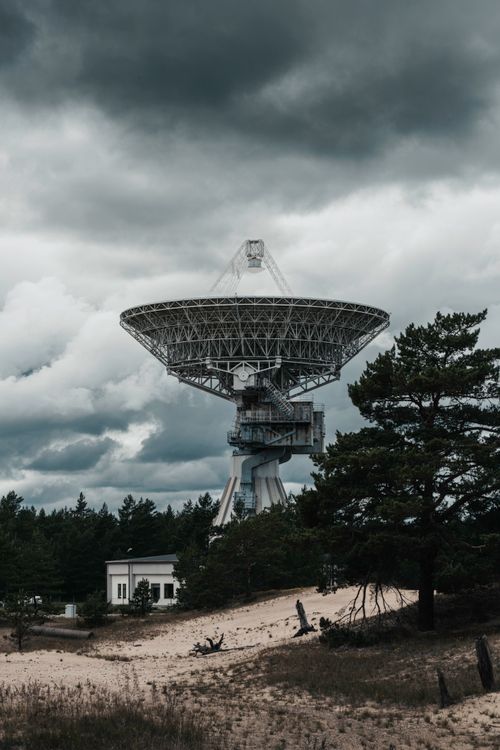 Free A large radio telescope set against a dramatic cloudy sky, capturing the essence of space technology in Latvia. Stock Photo