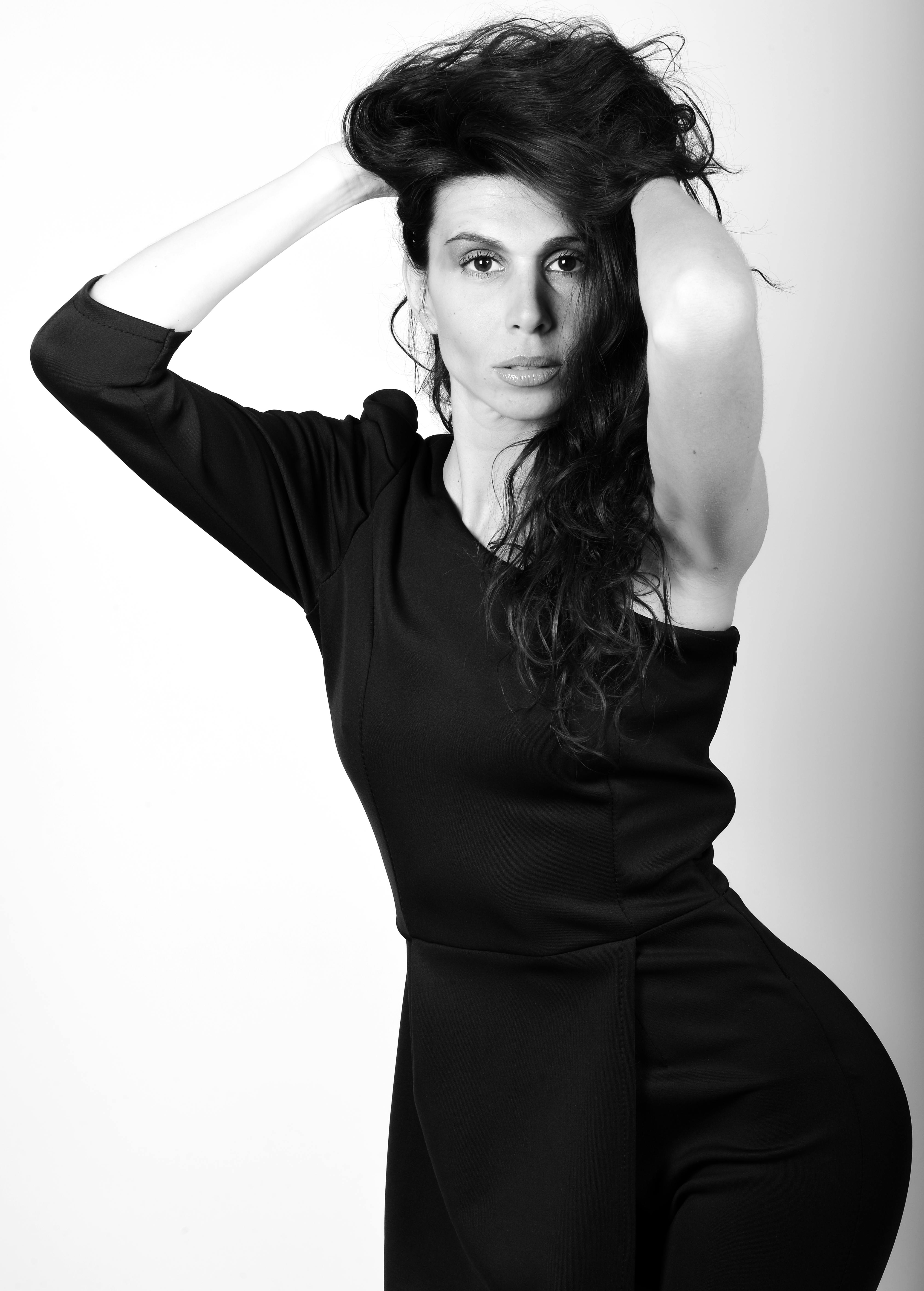 A striking black and white portrait of a woman in a stylish pose, showcasing elegance.