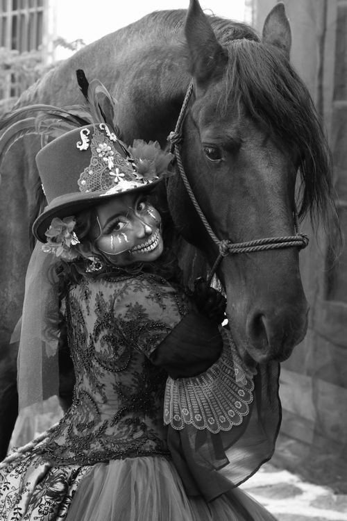 Free A woman in a Day of the Dead costume embraces a horse, showcasing festival elegance. Stock Photo