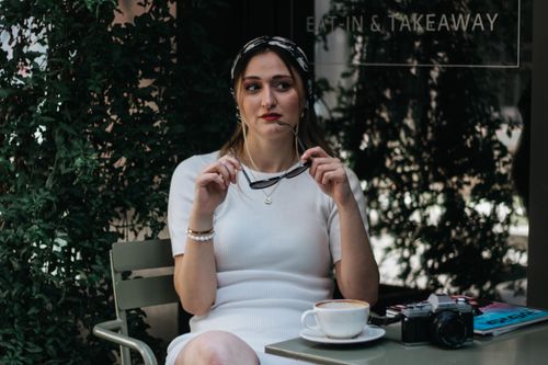 Free Woman sitting leisurely at a café, enjoying a coffee, wearing a headscarf; shot in Istanbul. Stock Photo