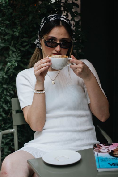 Free A fashionable woman sipping coffee at an outdoor café in İstanbul, Türkiye, exuding style and relaxation. Stock Photo