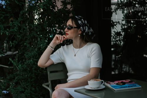 Free Fashionable woman in sunglasses seated at an Istanbul cafe, enjoying a coffee. Stock Photo