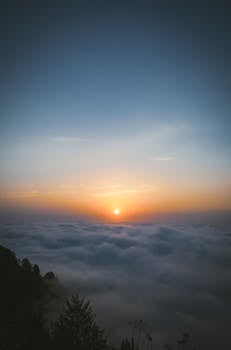 A breathtaking sunrise above a cloud-covered mountain landscape, creating a serene and peaceful ambiance.