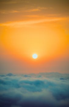 Breathtaking golden sunrise emerging above fluffy clouds with a warm glow.