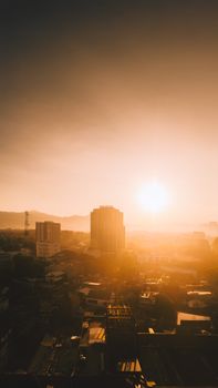 Beautiful sunset over a city skyline with golden hues and silhouetted buildings.