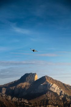 A drone captured flying over scenic Swiss mountains during sunset, presenting a breathtaking aerial view.