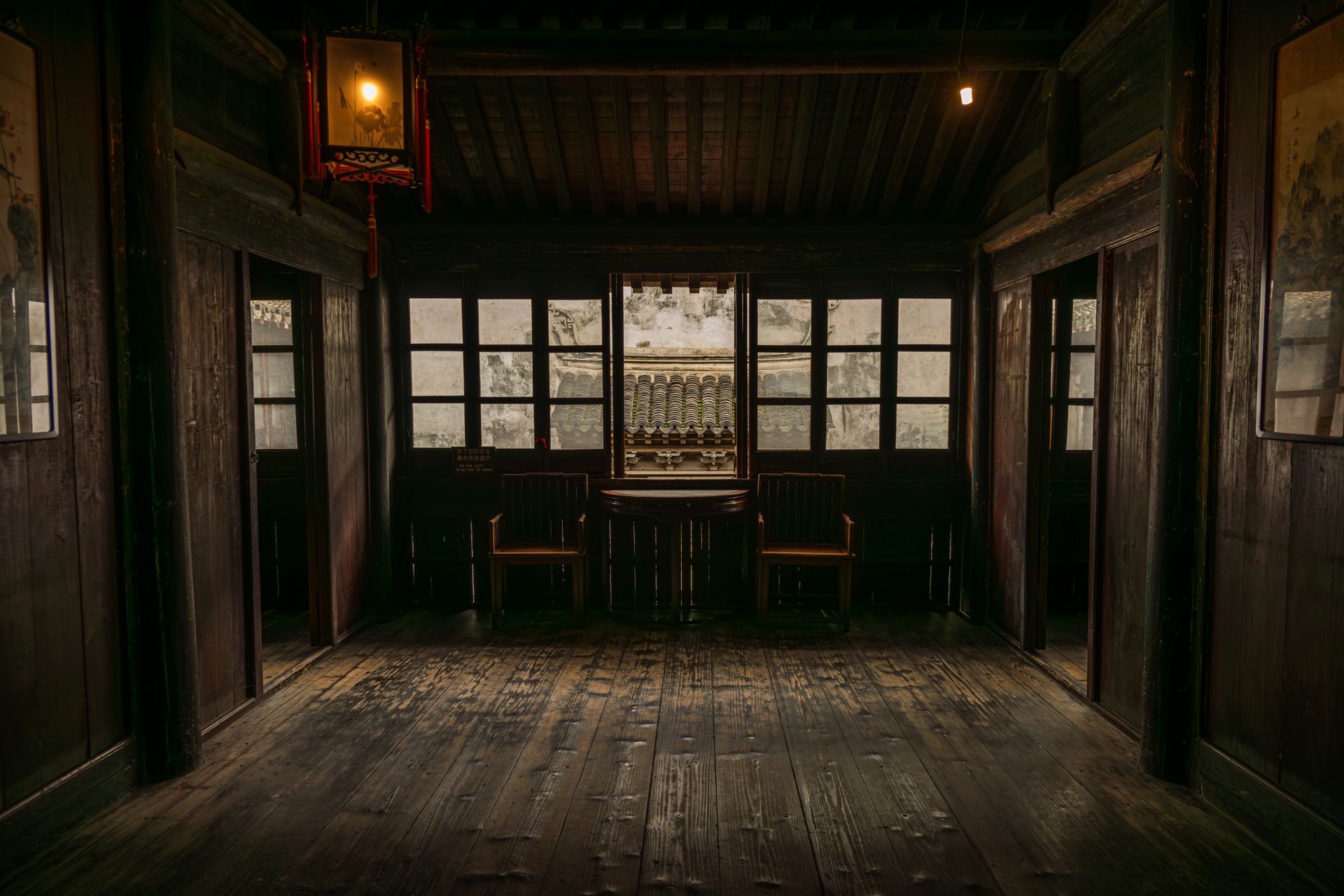 Dimly lit wooden room with traditional Asian architecture, offering a serene atmosphere.