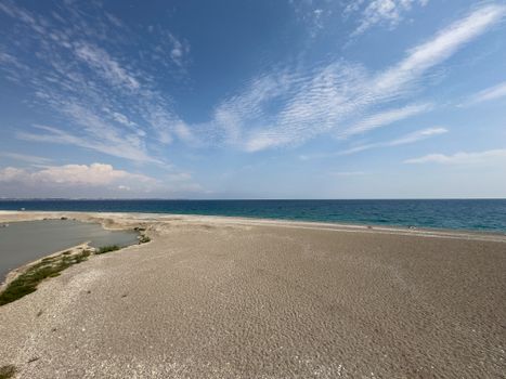 A peaceful sandy beach with a vibrant blue ocean under a clear sky, perfect for travel and relaxation.