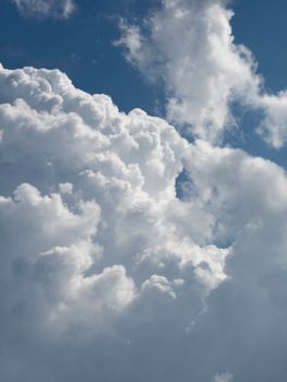 A scenic view of fluffy white clouds against a deep blue sky.