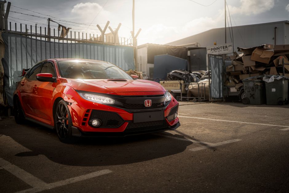 日中にキプロスの都市部に駐車された赤いホンダ シビック タイプ R のダイナミックなショット。