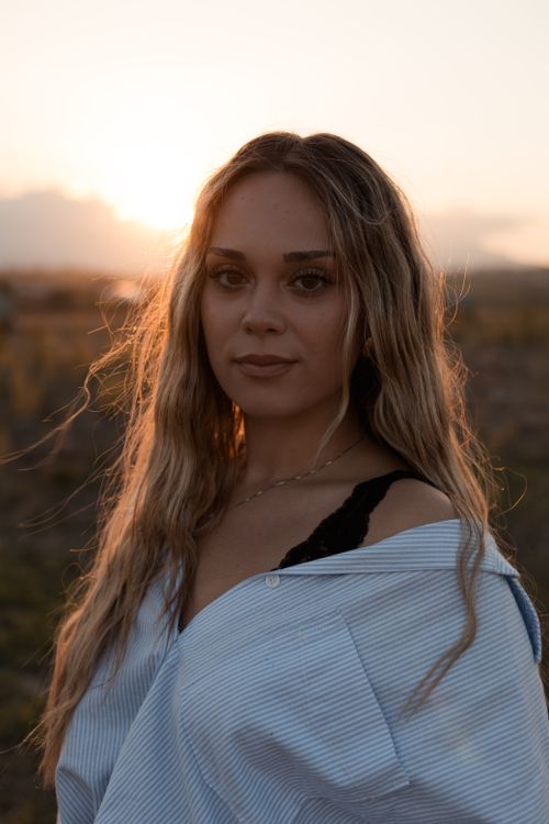 Free Portrait of a woman in golden hour light, showcasing serene beauty. Stock Photo