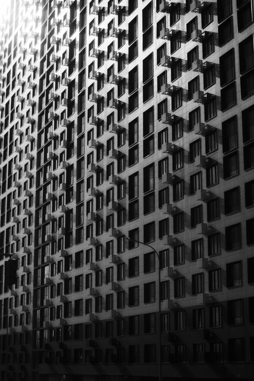 Free Dramatic black and white photo of modern apartment building facade creating a repeating pattern. Stock Photo