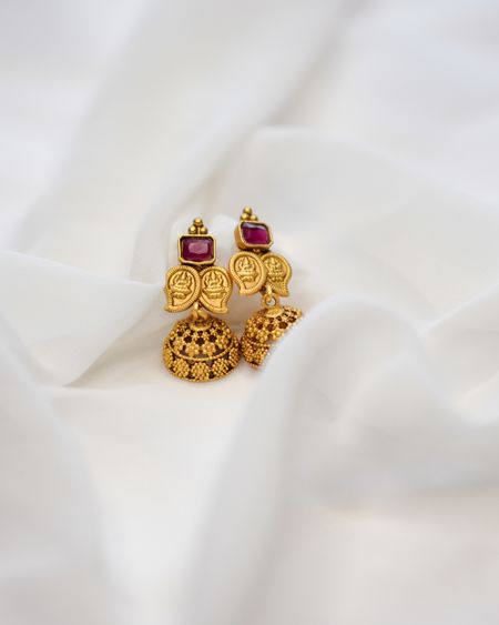 Petite gold jhumka earrings with ruby-red tops on white silk
